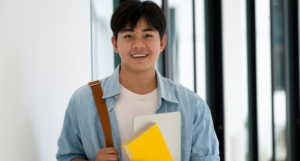 Male student in hallway holding text books