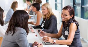 A woman is networking with a recruiter at a career fair stall.