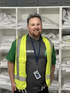 Andrew smiling with white linen shelving behind him